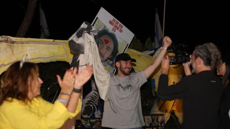 "מאוד מתרגש". עומר שם טוב והשלט שלו לאחר ששוחרר משבי החמאס (צילום: מוטי קמחי ) אירוע הורדת השלט בכיכר הרוקדים למען חזרתם של מיה ואיתי רגב לאחר ששוחררו משבי החמאס