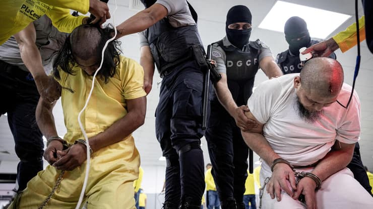 צילום: Secretaria de Prensa de la Presidencia/Handout via REUTERS מהגרים חברי כנופיית הפשע טרן דה ארגואה שגורשו מ ארה"ב מועברים ל כלא ב אל סלבדור