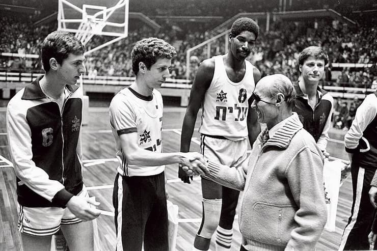 משה דיין לוחץ את ידיהם של שחקני מכבי תל אביב אולסי פרי, מיקי ברקוביץ' ומוטי ארואסטי