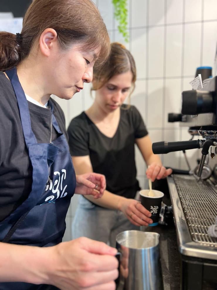 אחת מחברות המשלחת היפנית בהתלמדות עם אחת מהעובדות הישראליות (צילום: באדיבות "קפה שכולו טוב") המשלחת מיפן לומדת את ההכנות