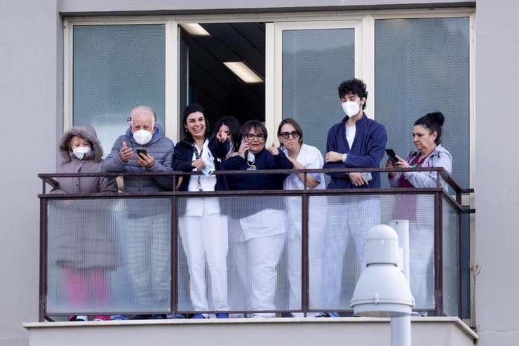 גם צוות בית החולים יצא למרפסת כדי לצפות באפיפיור (צילום: REUTERS/Remo Casilli) תומכי האפיפיור אפיפיור פרנסיסקוס מחכים לו עם שחרורו מ בית החולים ג'מלי ב רומא איטליה