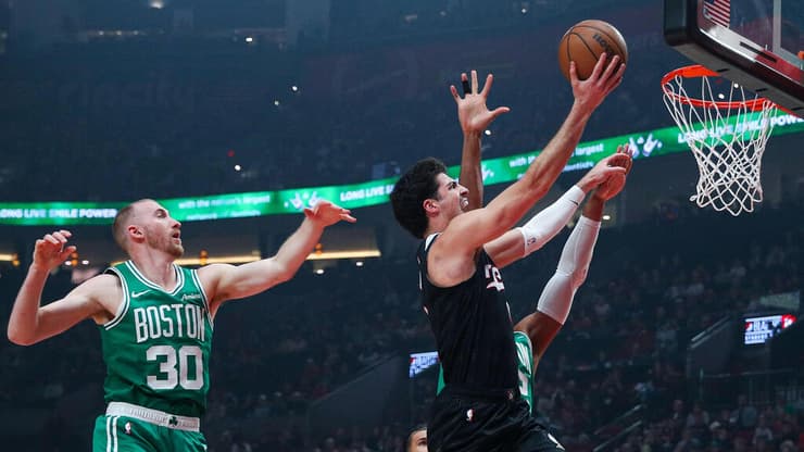 בדרך לסל (Rio Giancarlo / AFP) שחקן פורטלנד טרייל בלייזרס דני אבדיה מול שחקן בוסטון סלטיקס סאם האוזר