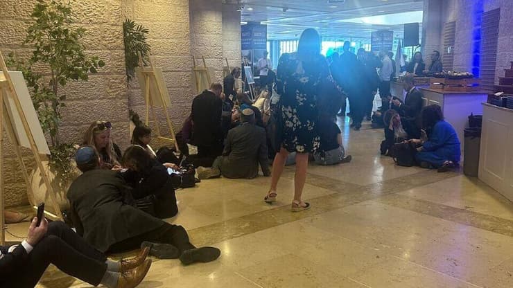 מתמגנים מהאזעקה במהלך כנס של הוועידה הבינלאומית למאבק באנטישמיות בירושלים