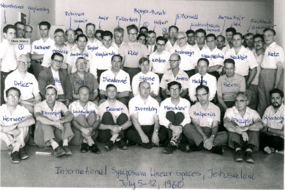קיבל משרה באוניברסיטה העברית בזכות בריחת המוחות. אגמון (עומד שמיני מימין) בסימפוזיון בינלאומי בנושא מרחבים ליניאריים בירושלים, 1960
