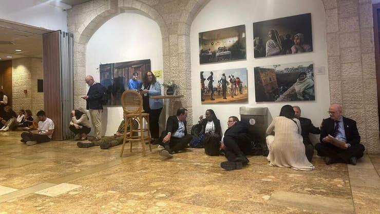 גם בזמן הוועידה: משתטחים על הרצפה מתמגנים מהאזעקה במהלך כנס של הוועידה הבינלאומית למאבק באנטישמיות בירושלים