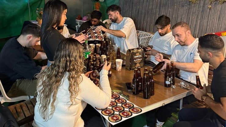 חבריו של אורי מדביקים תוויות על הבירה לזכרו