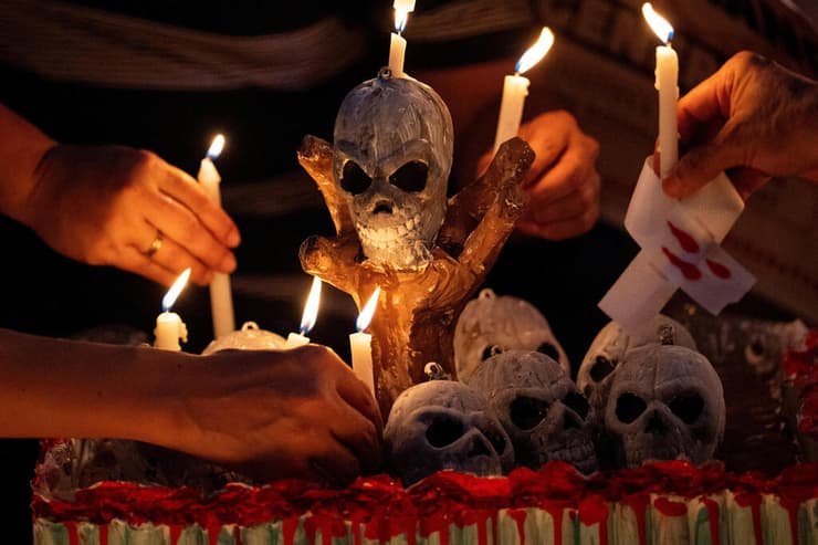 פעילים וקרובי משפחה של קורבנות מלחמת סמים מדליקים נרות בהפגנה במנילה, הפיליפינים