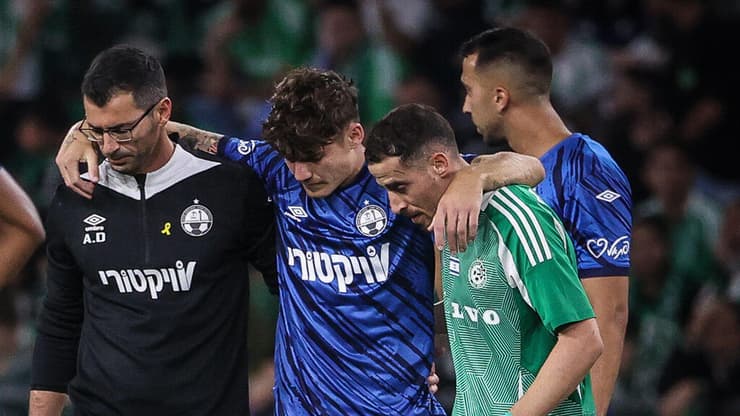 מכה לבאר-שבע יוני סטויאנוב יורד מכר הדשא (צילום: עוז מועלם) שחקן הפועל באר-שבע יוני סטויאנוב נשען על שחקן מכבי חיפה דולב חזיזה