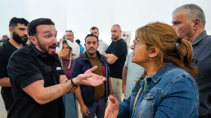 יורם כהן יוצא מהאולם בזמן שאזרחים מקיפים אותו בצעקות "בושה"