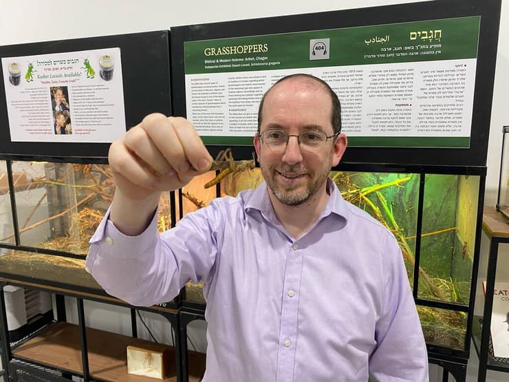 הרב ד"ר נתן סליפקין מחזיק חגב המכונה ארבה כאשר הוא מופיע בלהקה