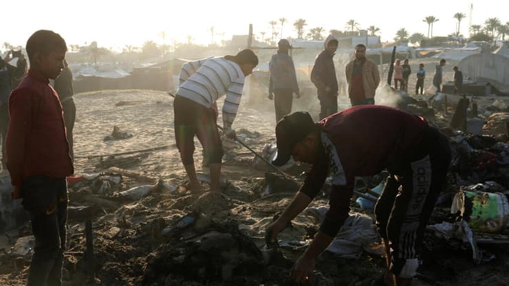 נזקי תקיפה בחאן יונס (צילום: REUTERS/Hatem Khaled) עזתים בודקים נזק באתר בו תקפה ישראל בחאן יונס