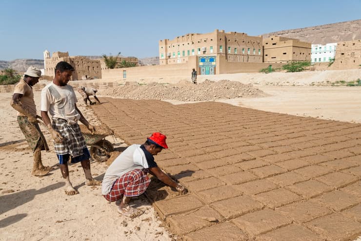 מבני בוץ יעילים בעיקר באזורים יבשים מאוד, מכיוון שהם חדירים למים ואין טעם לבנות אותם באזורים גשומים. הכנת לבני בוץ בשיטה מסורתית בתימן של ימינו (צילום: Editorial credit: dinosmichail / Shutterstock.com) מבני בוץ יעילים בעיקר באזורים יבשים מאוד, מכיוון שהם חדירים למים ואין טעם לבנות אותם באזורים גשומים. הכנת לבני בוץ בשיטה מסורתית בתימן של ימינו