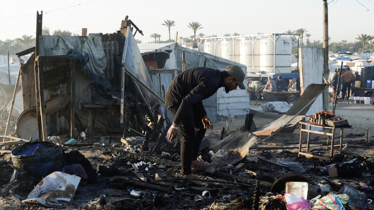 נזק אחרי תקיפה ישראלית בחאן יונס, אתמול (צילום: REUTERS/Hatem Khaled) עזתי בודק נזק באתר בו תקפה ישראל בחאן יונס