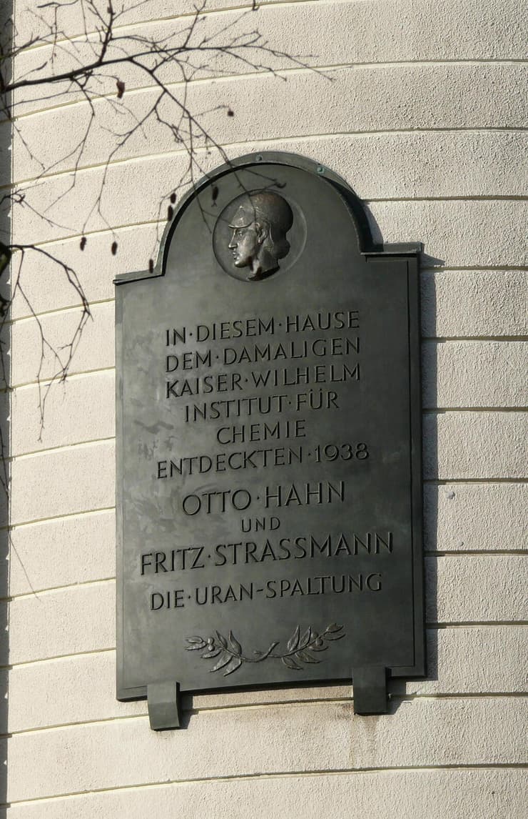 "בבניין זה, אז מכון קייזר וילהלם לכימיה, גילו ב-1938 אוטו האן ופריץ שטרסמן את ביקוע האורניום" - שלט זיכרון בבניין הישן של המכון בברלין (צילום: Fridolin freudenfett (Peter Kuley), Wikipedia) "בבניין זה, אז מכון קייזר וילהלם לכימיה, גילו ב-1938 אוטו האן ופריץ שטרסמן את ביקוע האורניום" - שלט זיכרון בבניין הישן של המכון בברלין