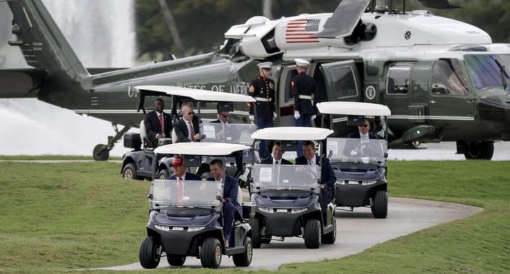 נוסע עם בנו אריק במגרש הגולף שלו בדורל, פלורידה. 3 באפריל