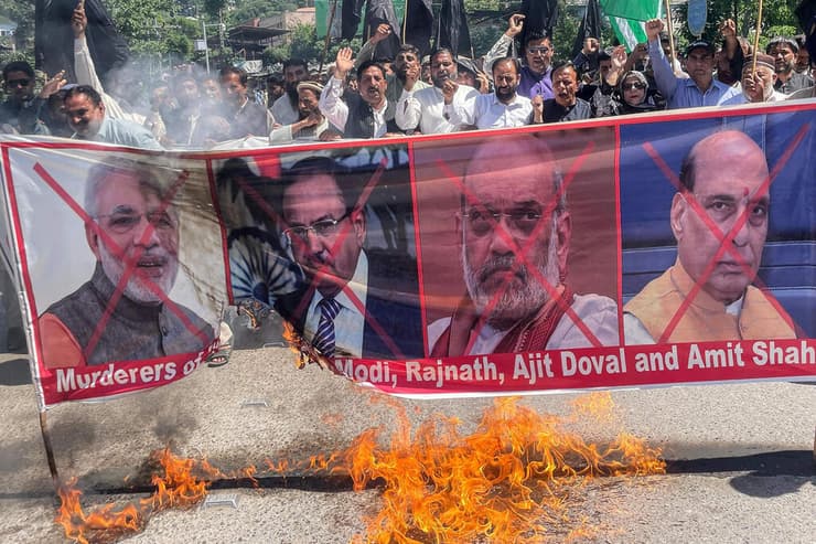 פקיסטינים שורפים את תמונת ראש ממשלחת הודו נרדרה מודג ובכירים נהודים אחרים ב הפגנה בחלק הפקיסטני של חבל קשמיר