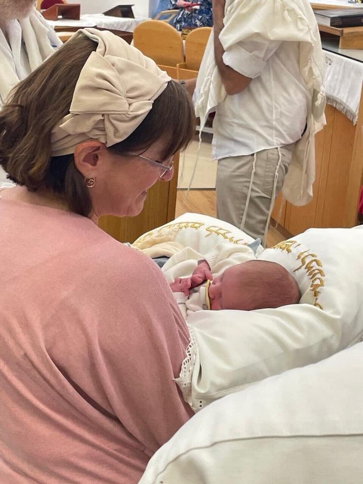 Marcy Oster holding her grandson, Adi Amichai, after the uncle he will never meet