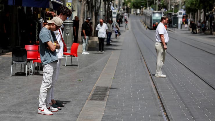 בירושלים, בזמן הצפירה (צילום: REUTERS/Ammar Awad) אזרחים עומדים במהלך צפירת יום הזיכרון לחללי מערכות ישראל ונפגעי פעולות איבה