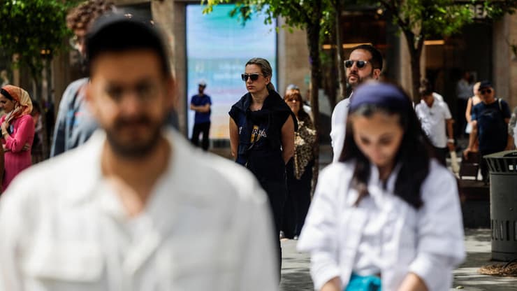 צילום: REUTERS/Ammar Awad אזרחים עומדים במהלך צפירת יום הזיכרון לחללי מערכות ישראל ונפגעי פעולות איבה