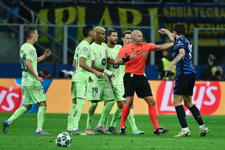 שחקני ברצלונה מקיפים את השופט שימון מרצ'יניאק (PIERO CRUCIATTI / AFP) שחקני ברצלונה מול השופט הפולני שימון מרצ'יניאק