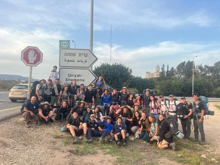 חניכי מכינת "תבור" בכניסה לקריית שמונה. להיות איפה שצריך (צילום: באדיבות מכינת "תבור") חניכי תבור על רקע שלט הכניסה לקריית שמונה