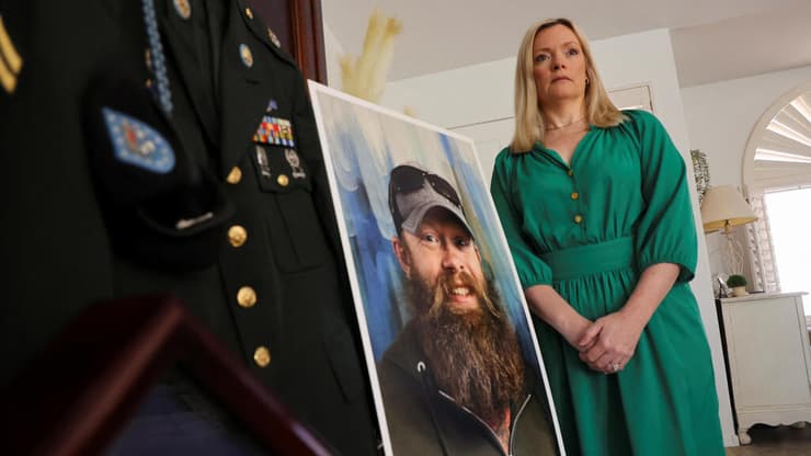 סטייסי וויילס לצד תמונתו של אחיה הנרצח, כריסטופר (רויטרס) סטייסי וויילס לצד תמונתו של אחיה הנרצח, כריסטופר