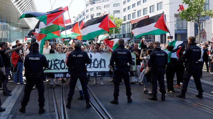 דגלי פלסטין בקהל במצעד המשלחות ( צילום: Stefan Wermuth / AFP) דגלי פלסטין בקהל במצעד המשלחות