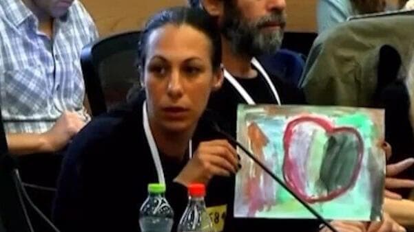 לישי מציגה את הציור שציירה רוני (צילום: ערוץ הכנסת ) לישי לביא מירן, אשתו של עמרי מירן מספרת בכנסת על הקושי של בתה רוני שאביה בשבי