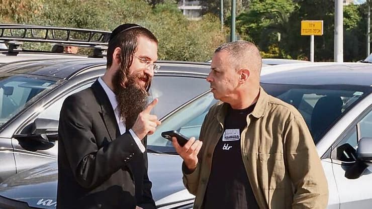 רענן שקד עם אחד המפגינים מחוץ לבקו"ם