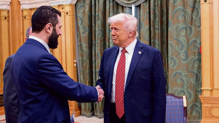 המארח מוחמד בן סלמאן מביט בלחיצת היד ההיסטורית בין אחמד א־שרע לדונלד טראמפ