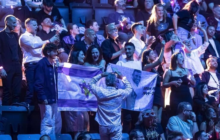 הילה אביר מניפה את הדגל בקהל, בזמן הופעת חצי הגמר של יובל רפאל