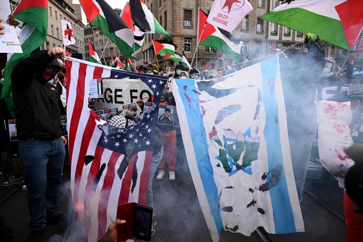 שריפת דגלי ישראל וארה"ב בהפגנה פרו-פלסטינית באירופה (צילום: SEBASTIEN BOZON / AFP) הפגנה פרו פלסטינית מחוץ ל אירווזיון 2025