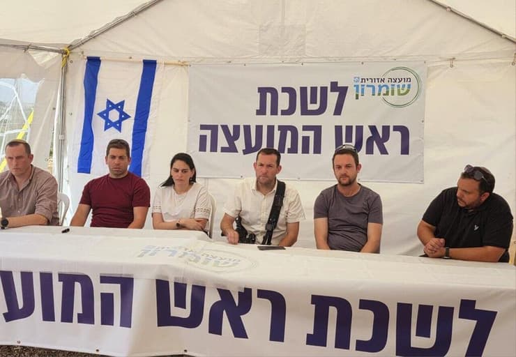 יוסי דגן (במרכז) בלשכתו במקום הפיגוע, היום