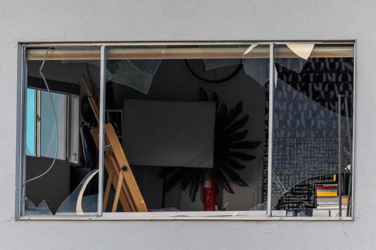 חלון שהתנפץ בגוש בניינים אחר, סמוך למרפאה, בעקבות הפיצוץ (צילום: DAVID MCNEW / GETTY IMAGES NORTH AMERICA / AFP) ארה"ב דרום קליפורניה פאלם ספרינגס פיצוץ מרפאה מרפאת פוריות פיגוע טרור חלון מנופץ בבית עסק אחר במרחק בלוק