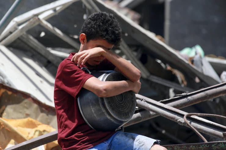 ילד עם סיר ריק בג'באליה (צילום: Bashar TALEB / AFP) ג'באליה