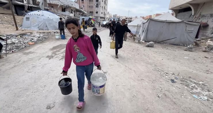 "אני לבד. רגשית אני כבר מתה". ג'אנה סוחבת דליים בעזה (מתוך CNN) ג'אנה סוחבת דליים בעזה