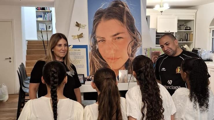 ענת נעים וגילי אלגבי עם בנות המצווה על רקע תמונת מאי ז"ל