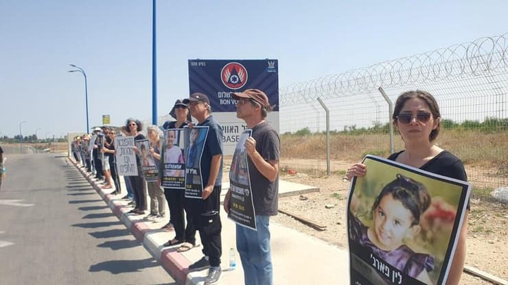 פעילים מוחים מחוץ לבסיס חצור, כשבידיהם תמונות של ילדים עזתים שנהרגו מהפצצות בעזה