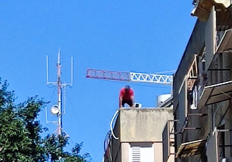 החשוד על גג הבניין. "המו"מ איתו בעיצומו" (צילום: ליאור שרון) החשוד ברצח מאיים לקפוץ מגג הביניין