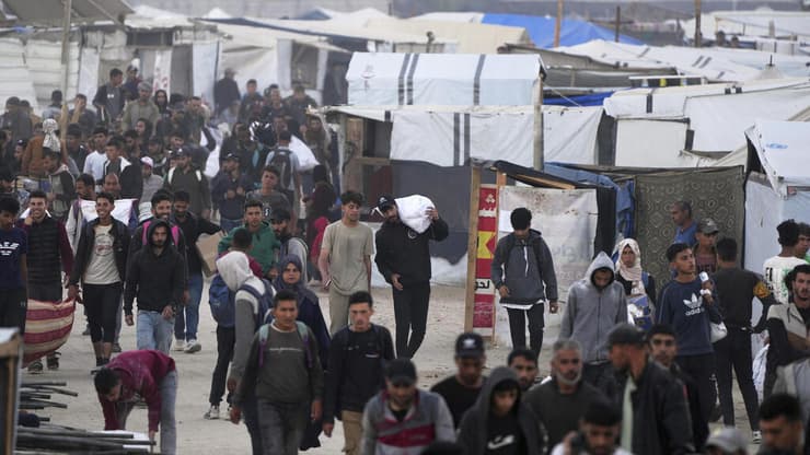 עזתים נושאים סיוע בחאן יונס (צילום: AP Photo/Abdel Kareem Hana) חאן יונס