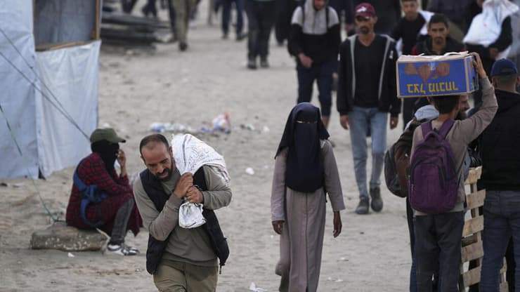 עזתים נושאים סיוע ישראלי בחאן יונס (צילום: AP Photo/Abdel Kareem Hana) חאן יונס