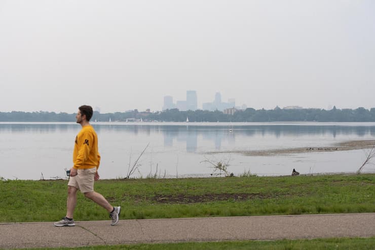 על שפת האגם במיניאפוליס. "זה ישפיע על כולם, זה רע" (צילום: REUTERS/Tim Evans/File Photo) קנדה שריפות עשן מכסה שליש משטח ארה"ב כאן ב מיניאפוליס מינסוטה