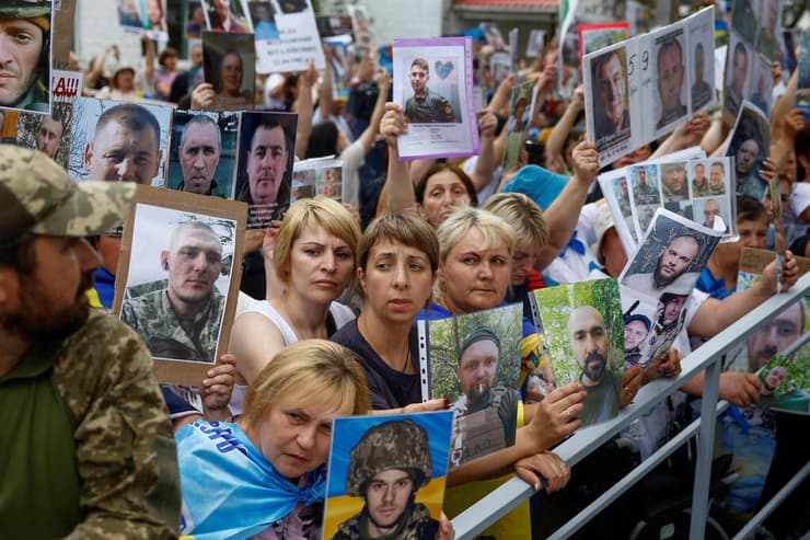 בני משפחה של שבויי מלחמה של אוקראינה עם תמונות יקיריהם הנעדרים בצל עסקת שבויים עם רוסיה