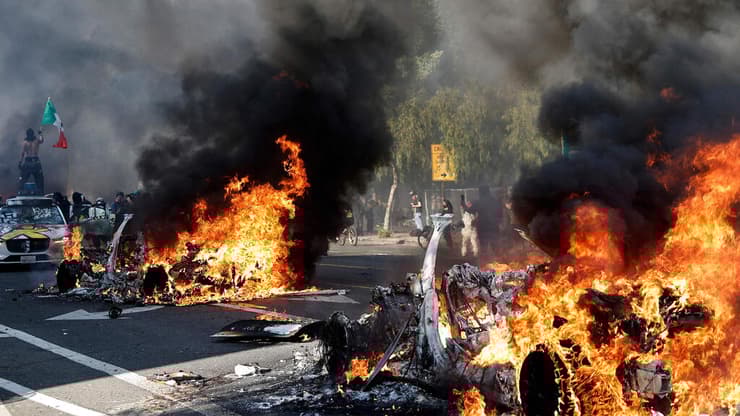 התפרעויות אחרי מעצר מהגרים לא חוקיים (צילום: MARIO TAMA / GETTY IMAGES NORTH AMERICA / AFP) ארה"ב קליפורניה לוס אנג'לס מפגינים שורפים כלי רכב אוטונומיים מהומות בעקבות מעצר מהגרים בלתי חוקיים