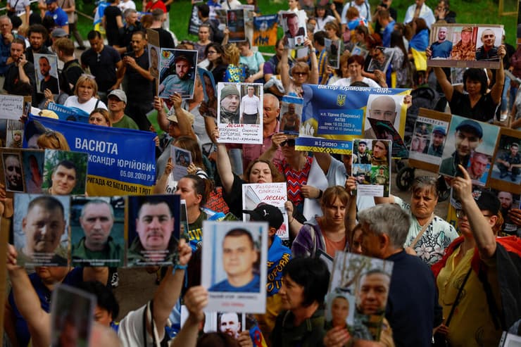 בני משפחה של שבויי מלחמה של אוקראינה עם תמונות יקיריהם הנעדרים בצל עסקת שבויים עם רוסיה
