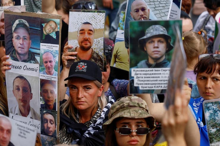בני משפחה של שבויי מלחמה של אוקראינה עם תמונות יקיריהם הנעדרים בצל עסקת שבויים עם רוסיה