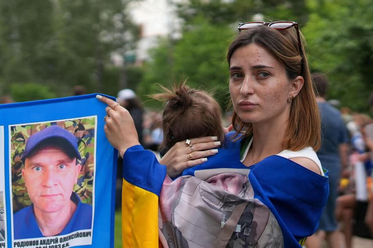 בני משפחה של שבויי מלחמה של אוקראינה עם תמונות יקיריהם הנעדרים בצל עסקת שבויים עם רוסיה