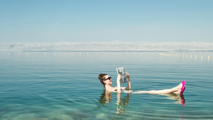 תיירת צפה להנאתה בים המלח. לפחות אין בעיה של עומס תיירים וצפיפות