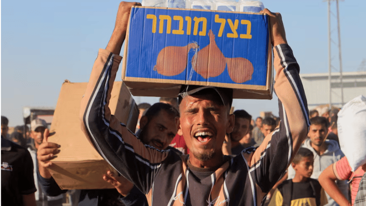 סיוע הומניטרי בעזה (צילום: REUTERS/Hatem Khaled Purchase Licensing Rights) פלסטיני סוחב סיוע הומניטרי