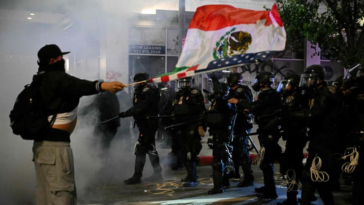 הפגנות נגד גירוש מהגרים בקליפורניה (צילום: RONALDO SCHEMIDT / AFP) דגל מקסיקו ונף ב הפגנה נגד גירוש מהגרים ב לוס אנג'לס קליפורניה ארה"ב 9 ביוני